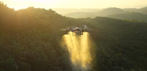 Agras T50 Drohne im Flug Sprühbetrieb vor bergiger Landschaft