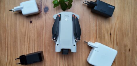 Mehrere USB PD Netzteile liegen um eine DJI Mini 3 Pro Drohne verteilt.